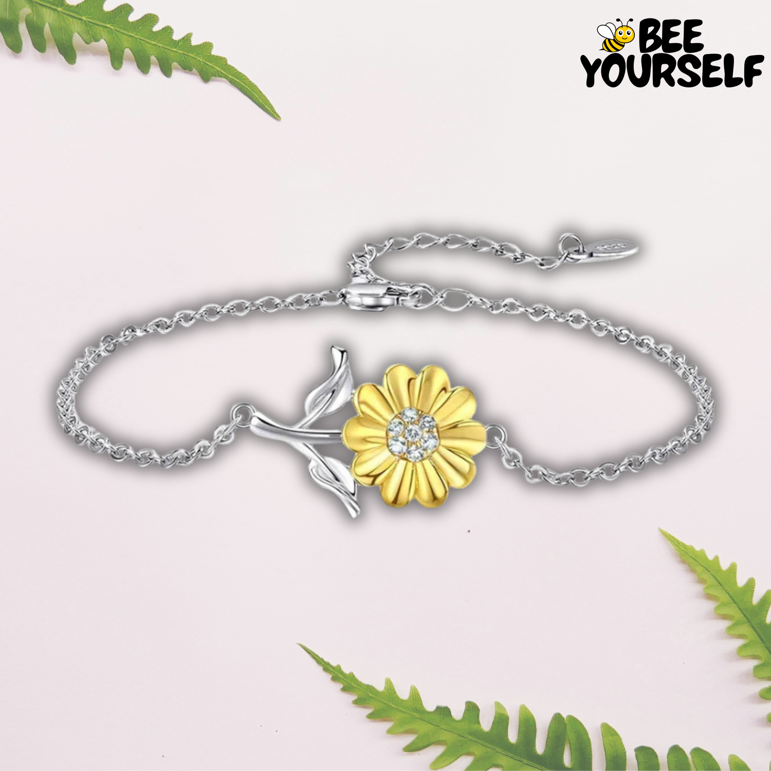 Image du Bracelet Tournesol d'Amour représentant un bijou délicat avec une chaîne en argent et un pendentif tournesol doré au centre. Le tournesol, richement détaillé avec des pétales dorés et un cœur orné de pierres brillantes, est suspendu à une fine chaîne argentée. Ce bracelet symbolise la tendresse et l'élégance, parfait pour ajouter une touche romantique et lumineuse à toute tenue.